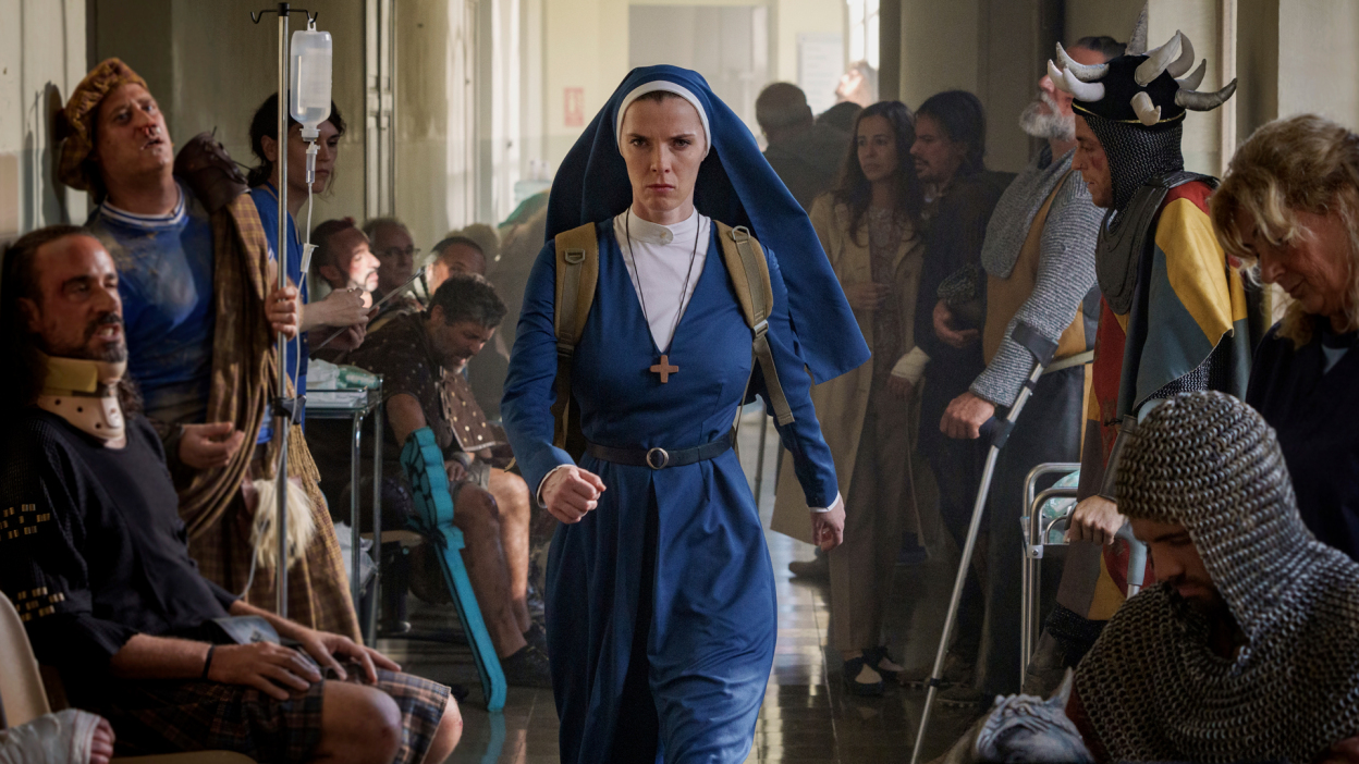 A nun in blue strides with purpose through a hospital.