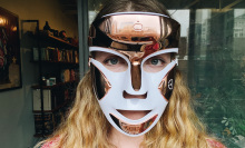 woman wearing gold and white LED face mask