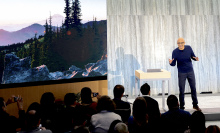 Microsoft's CEO standing in front of a crowd of journalists, casting a shadow