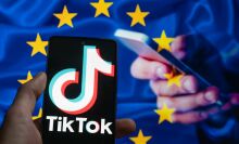 TikTok icon displayed on a phone screen with in the background European Union Flag seen in this photo illustration.