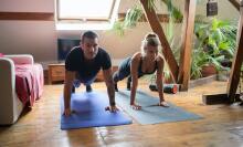 man and woman doing yoga indoors