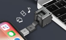 wondercube device is connected to the port of a macbook and the charging socket of an iphone, demonstrating its charging and storage capabilities against a black background