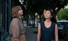 Michelle Williams and Hong Chau stand on the sidewalk in "Showing Up." 