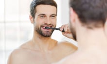 Man brushing his teeth in the mirror