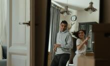 A man and woman dance in an apartment.