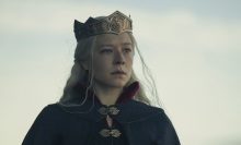 Rhaenyra Targaryen, a woman with silver blonde hair, a black cape, and a crown on her head.