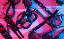 A set of leather erotic toys for BDSM, including a whip, gag and leather blindfold.