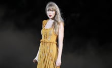 Taylor Swift in a yellow dress standing on stage of The Eras Tour