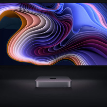 Mac mini M1 2020 desktop in front of Apple monitors with colorful images on display