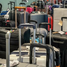 Several bags of luggage sit in an airport area. 