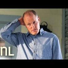Balding Woody Harrelson in blue button up