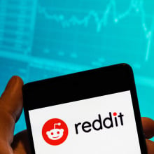 CHINA - 2023/02/15: In this photo illustration, the American social news aggregation, web content rating and discussion website, Reddit logo is seen displayed on a smartphone with an economic stock exchange index graph in the background.