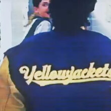 A close-up of the back of a girl's sports jacket that reads "yellowjackets".