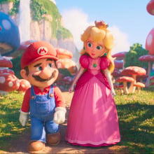 A man in overalls and a woman in a pink dress stroll though a mushroom field. 