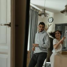 A man and woman dance in an apartment.