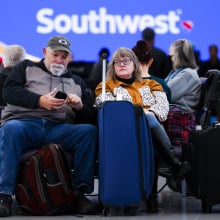 Airline passengers at a Southwest gate with their lugggage.