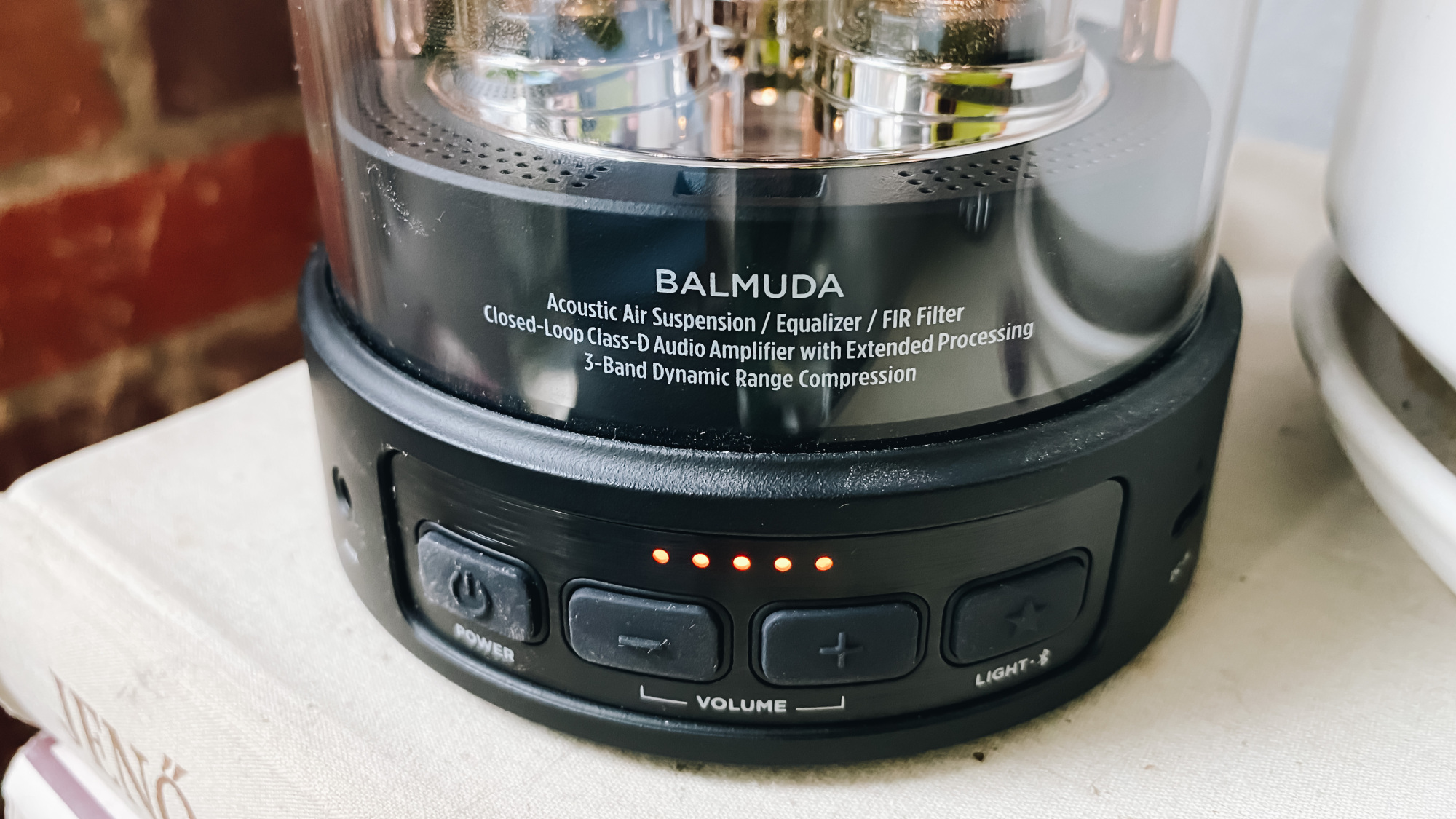 power, volume, and light buttons at the bottom of the balmuda speaker