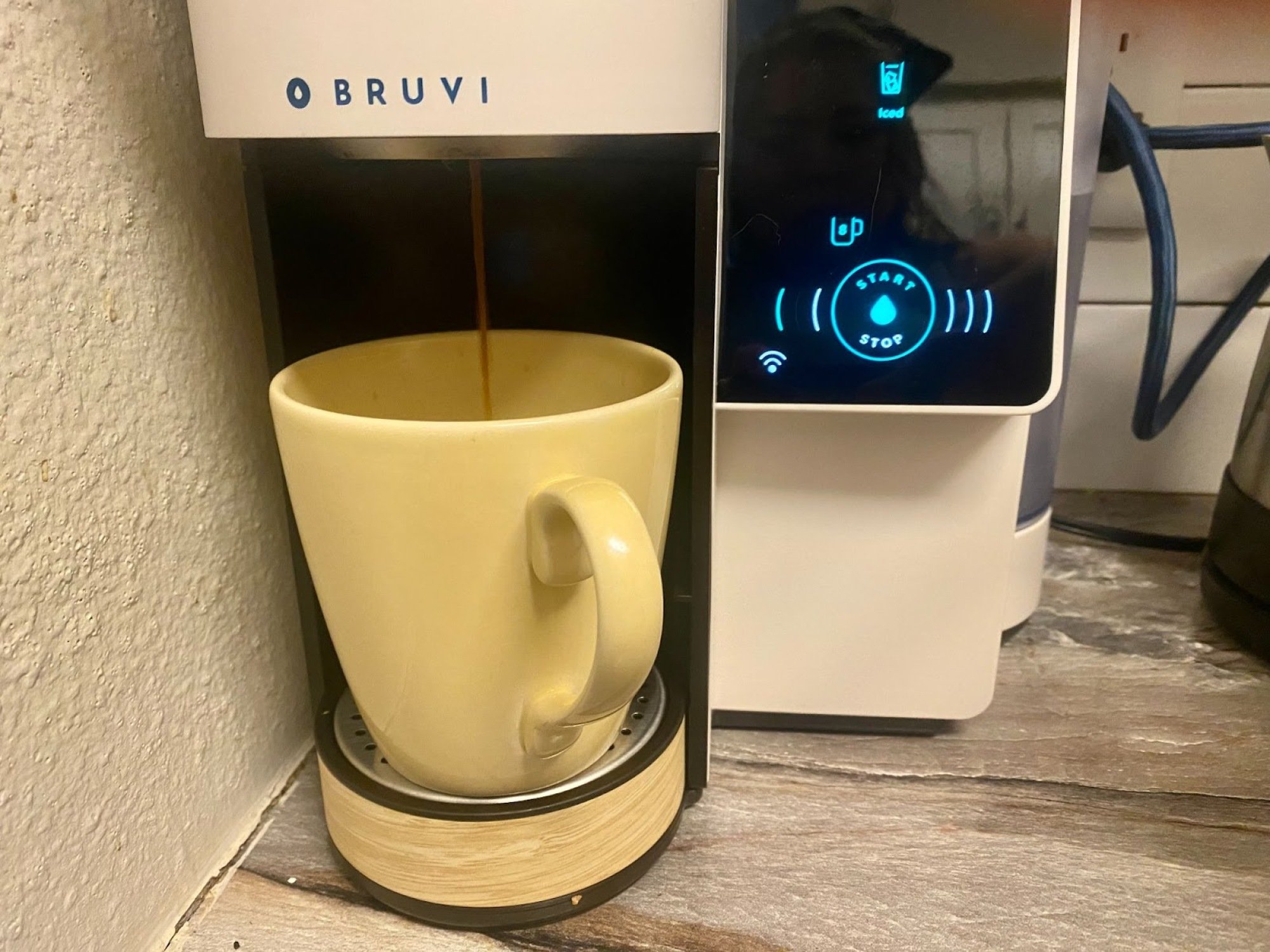 yellow coffee mug filling up with coffee from Bruvi machine