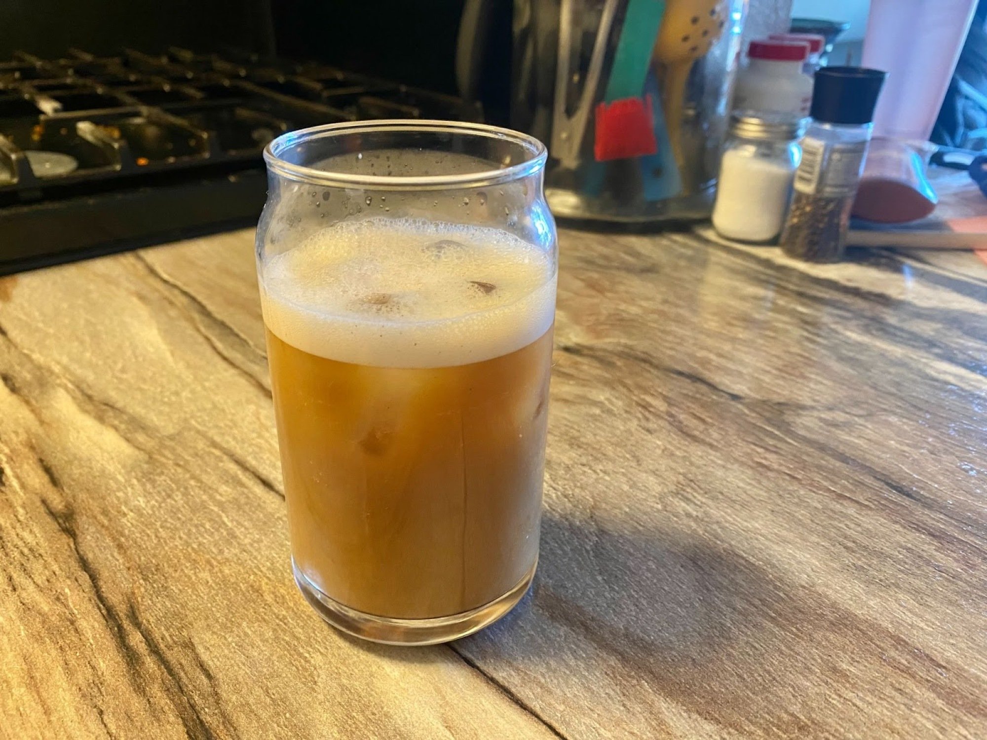 iced coffee with foam on top in glass cup