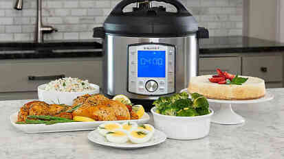 instant pot surrounded by dishes of food on kitchen table