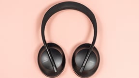 a pair of bose 700 headphones against a pastel pink background