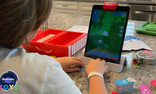 kid playing a coding game on an iPad