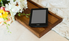 Kindle e-readr sitting on a wooden breakfast tray 