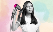 Woman using Dyson Supersonic hair dryer on pastel background