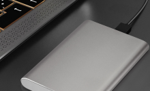 ultra-slim portable hard drive plugged into side of laptop