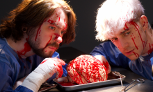 Sean and Ethan huddle over a bloody brain on a dissecting plate.