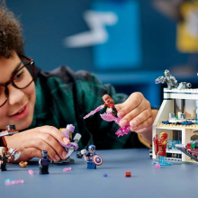 Child leaning over table playing with Marvel 'Avengers: Endgame' LEGO set
