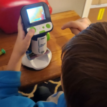 child playing with plastic microscope with screen