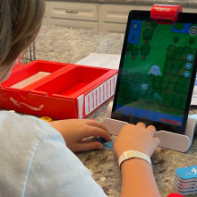 kid playing a coding game on an iPad