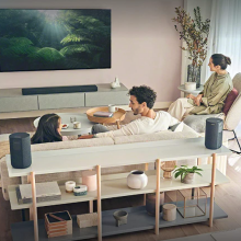 girl, man, and woman on a living watching a flatscreen TV during the day