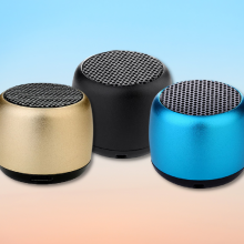 little wonder solo bluetooth speakers in gold, black, and blue with gradient background