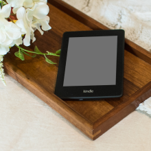 Kindle e-readr sitting on a wooden breakfast tray 