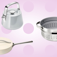 beige pan on bottom left, grey tea kettle on top center, metal steamer to the right against pink background with pink polka dots