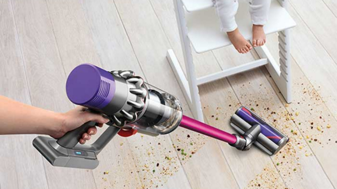 Woman using Dyson V10 to clean up a mess on a hardwood floor