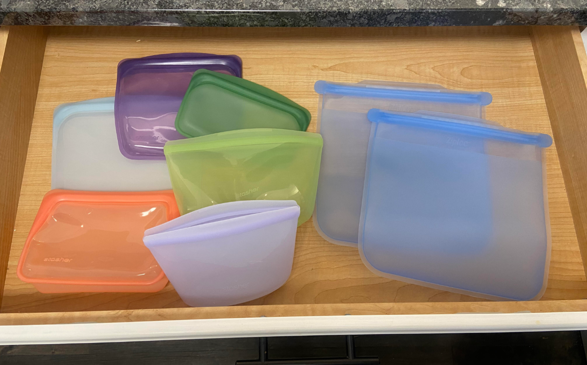 a top-down view of reusable silicone storage bags in a kitchen drawer