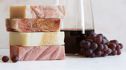 Glass of wine next to four bars of soap stacked 