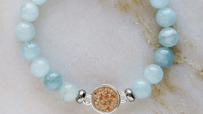 Blue beaded bracelet with sand-filled charm